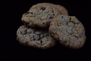 Cookies mit Schokolade. Kekse mit scharfen Kanten auf dunklem Hintergrund