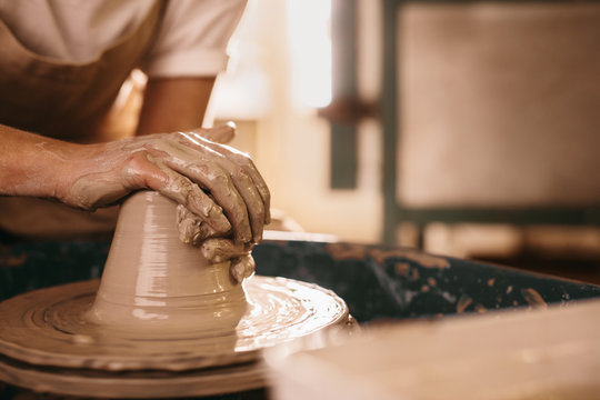 Potter moulding clay on pottery wheel