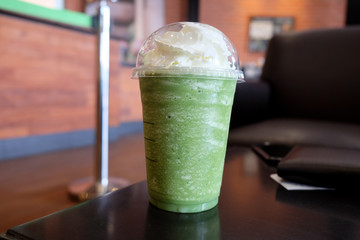 Green tea frappe on the wooden table