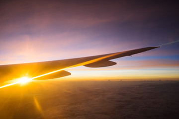 View of beautiful sunrise and flare outside airplane window