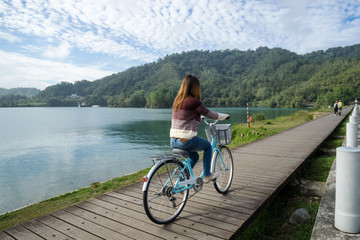 Obraz premium Young woman riding bicycle on Sun Moon lake bike trail