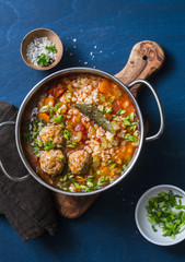 Multi grain, meatballs and vegetables soup in a pot on a blue background, top view. Comfort home cooking healthy seasonal food concept