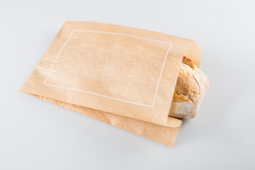 Fresh baguette in a paper bag isolated on a white background