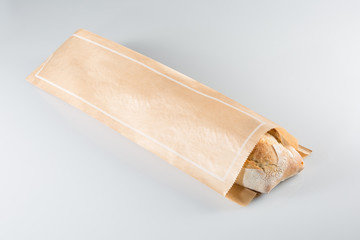 Baguette in paper bag isolated on white background