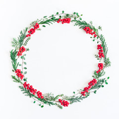 Christmas composition. Wreath made of christmas tree branches and red berries on white background. Flat lay, top view, copy space, square