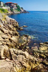 Coastal landscape - the rocky seashore with houses the sunny day, town of Sozopol on the Black Sea coast in Bulgaria