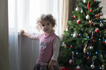 Girl playing in the room with a Christmas tree