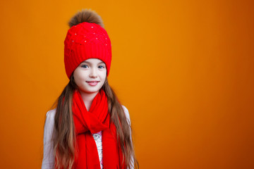 little girl in a red hat and scarf on a yellow background
