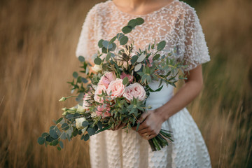 big wedding bouquet in hands of the bride