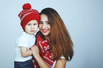 Happy mother and child with Christmas hat hugging on a blue background
