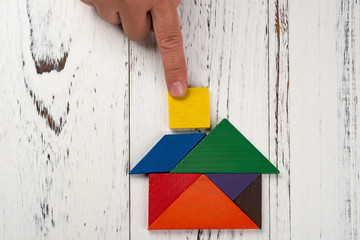 finishing the last bit of wooden tangram in a house shape