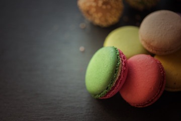 French colorful macarons on black background