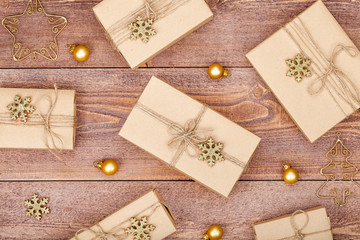 homemade wrapped christmas and new year present boxes and decoration on wooden background. holiday and celebration concept. above view, flat lay.