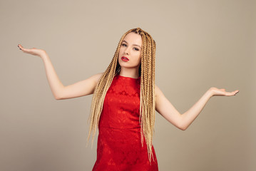 Stylish young woman in red dress weighs on hands