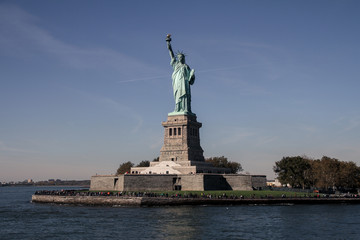 Fototapeta premium Freiheitsstatue vom Boot mit Insel, mit blauem Himmel, New York