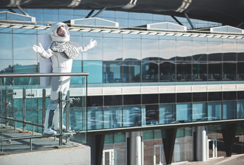 Naklejka premium Happy seeing the sun. pleased cosmonaut is standing at balcony and open arms to sunlight. Copy space on right side