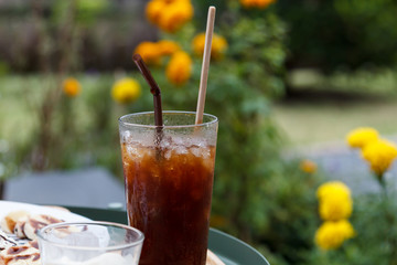 Delicious ice coffee americano with waffles and banana in garden