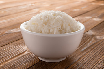 bowl full of rice on wood background