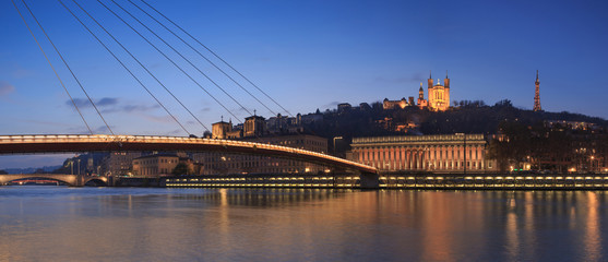 Fototapeta na wymiar Panorama of footbridge ’Passerelle Palais du Justice’ over the Saone river in Lyon during twilight.