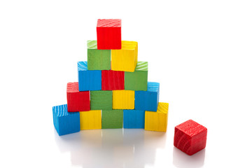 colorful wooden toy blocks stack up on a white background