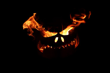 Halloween Kürbis in Flammen, Feuergesicht isoliert auf schwarz
