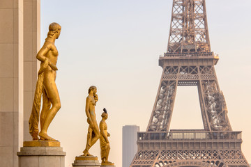 Fototapeta na wymiar Golden bronze statues on Trocadero square, Eiffel tower in the background, Paris France