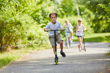 Aktive Kinder fahren mit dem Roller