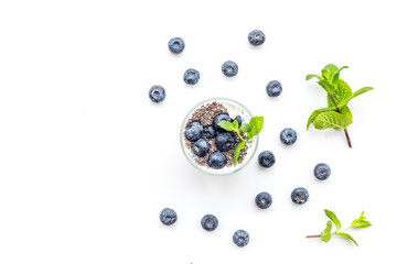 Light dessert with chia seeds, yogurt, blueberry and mint. White background top view copyspace