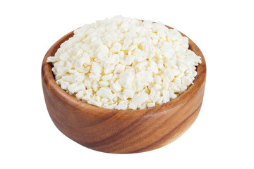 Cottage cheese in rustic wooden bowl, isolated on white.