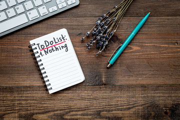 Planning day in the morning. Notebook with to do list near lavender flower branches and keyboard on wooden background top view