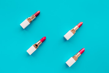 Lipsticks assorted colors on blue background top view