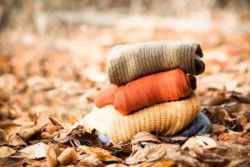 Knitted wool sweaters. Pile of knitted winter, autumn clothes