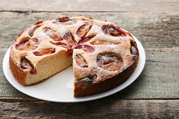 Sweet plum cake on grey wooden table