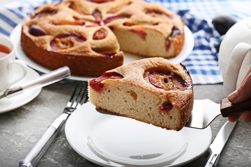 Sweet plum cake on grey wooden table