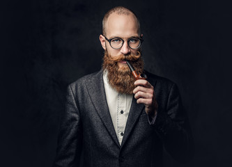A man smoking pipe over grey background.