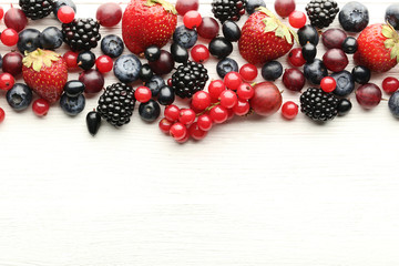 Ripe and sweet berries on white wooden table