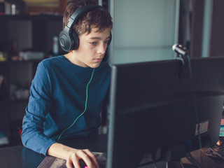 Teenager playing at computer game