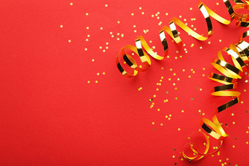 Golden ribbons with confetti on red background