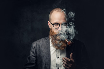 A man smoking pipe over grey background.