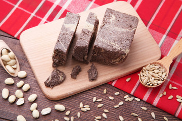 Tasty pieces of halva with cocoa on cutting board