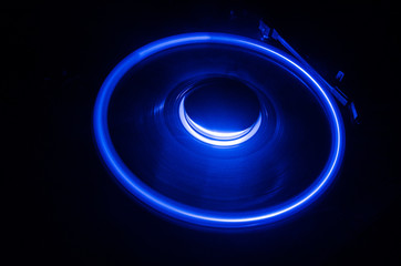 Turntable playing vinyl with glowing abstract lines concept on dark background. Selective focus