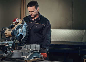 A man works with circular saw.