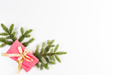 Christmas background. Christmas tree branch and present with gold ribbon on white background