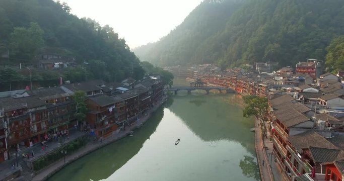Top view or aerial shot of famous ancient town in Fenghuang County, China. Flying over Green River, hills and houses of the village. Travel,destination and world heritage concept.