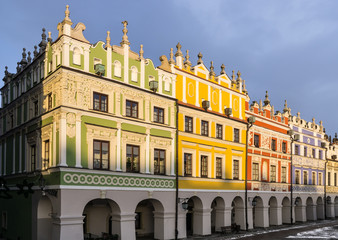 Fototapeta na wymiar Baroque Armenian tenement houses in Zamość, Poland. Colourful facades against dark blue sky.