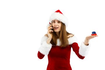 Beautiful woman in Santa Claus clothes using smartphone on white background