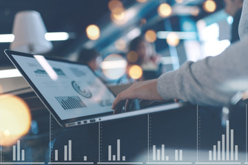 Meeting room concept. General business discussion in cozy open space office. Laptop close-up. Stats and graphs overlay