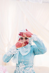 Portrait of beautiful woman showing her hennaed hands with wedding dress.