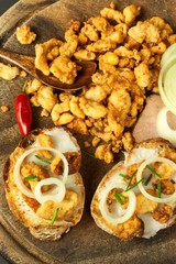 Heap of domestic salty fried pork greaves. Fatty junk food. Pork greaves on the kitchen board.