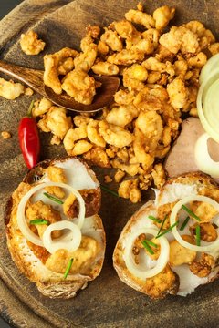 Heap of domestic salty fried pork greaves. Fatty junk food. Pork greaves on the kitchen board.